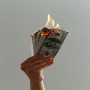 five one hundred dollar bills set on fire