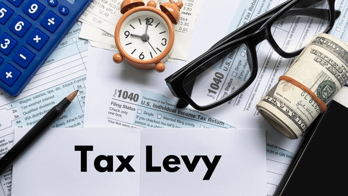 Tax-related items such as IRS Form 1040, a calculator, a clock, glasses, and a rolled-up stack of money are present. The text "Tax Levy" is displayed prominently, indicating the focus on financial and tax matters, likely concerning the implications of a tax levy or financial obligations.